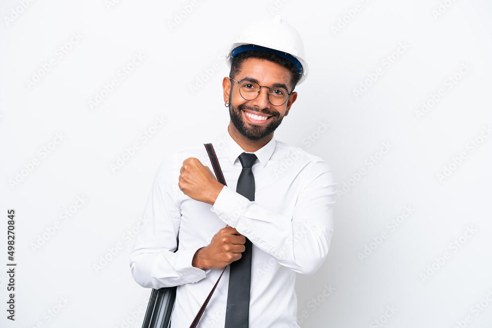 Young architect Brazilian man with helmet and holding blueprints isolated on white background celebrating a victory Young architect Brazilian man with helmet and holding blueprints isolated on white background celebrating a victory