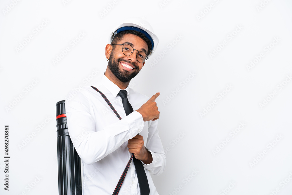 Young architect Brazilian man with helmet and holding blueprints isolated on white background pointing back Young architect Brazilian man with helmet and holding blueprints isolated on white background pointing back