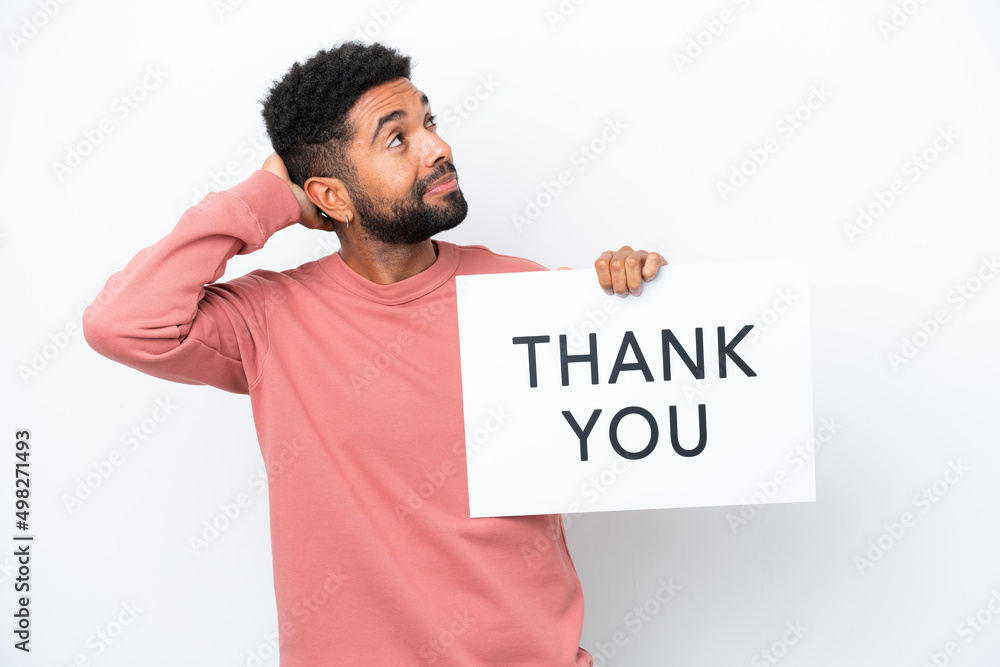 Young Brazilian man isolated on white background holding a placard with text THANK YOU and thinking Young Brazilian man isolated on white background holding a placard with text THANK YOU and thinking