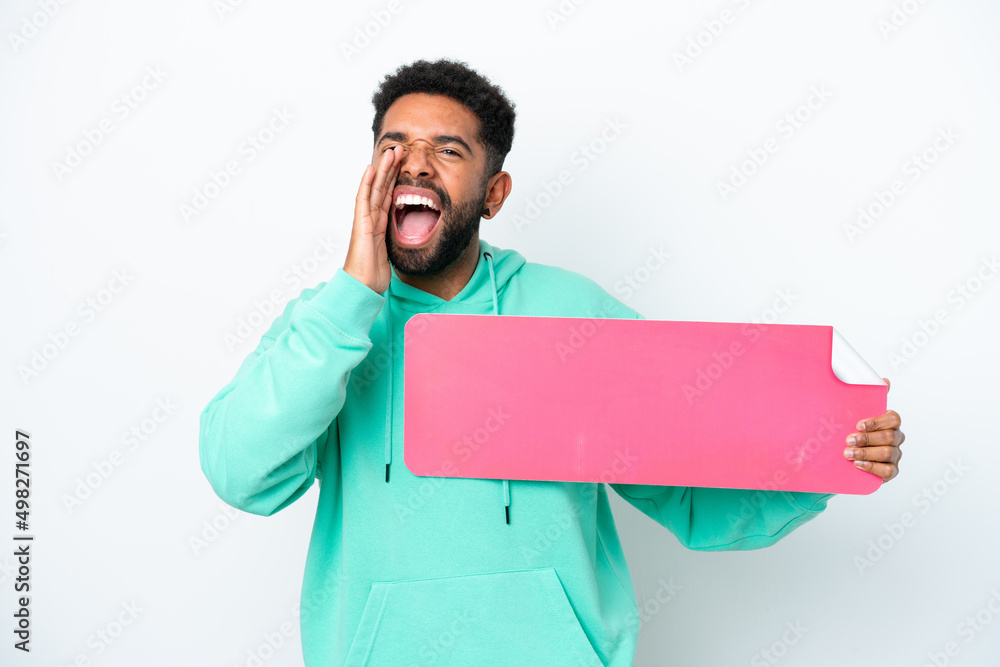 Young Brazilian man isolated on white background holding an empty placard and shouting Young Brazilian man isolated on white background holding an empty placard and shouting