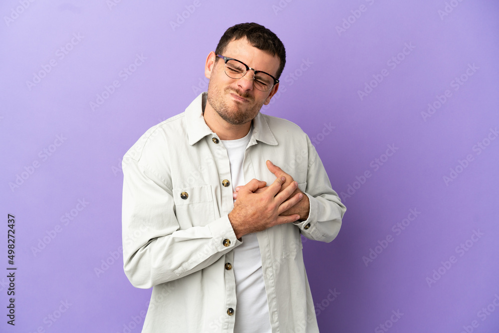 Brazilian man over isolated purple background having a pain in the heart Brazilian man over isolated purple background having a pain in the heart