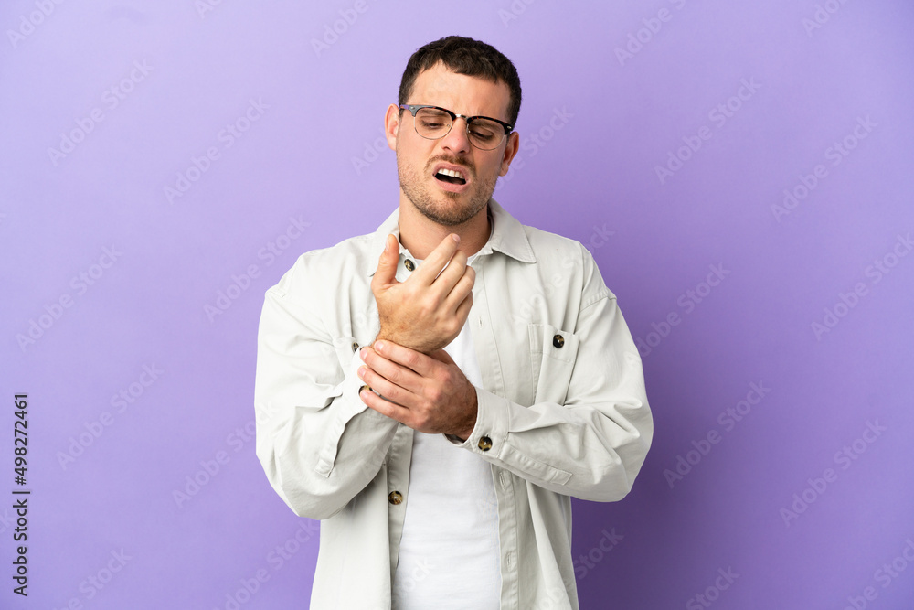 Brazilian man over isolated purple background suffering from pain in hands