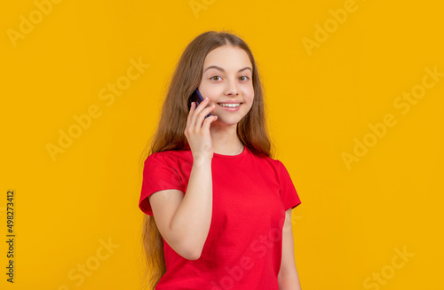 cheerful girl with smartphone on yellow background
