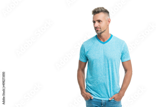 Happy handsome caucasian guy in casual style looking aside holding hands in pockets