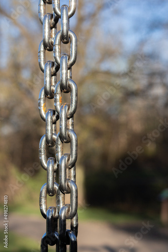 Black iron chain links hanging on a background
