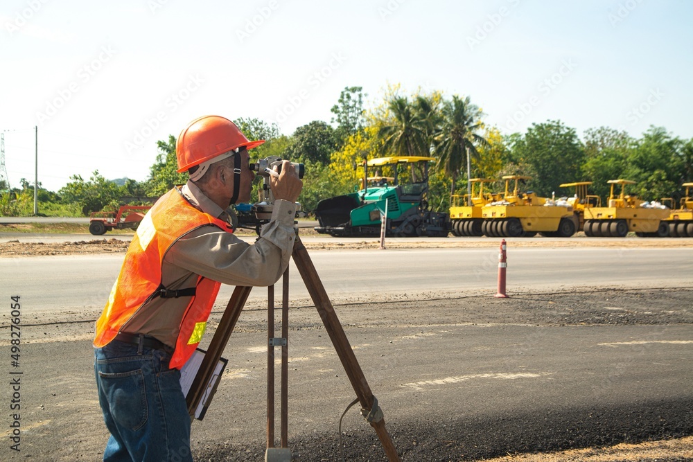 Engineer or surveyor working with theodolite equipment at road construction site. Engineer or surveyor working with theodolite equipment at road construction site.