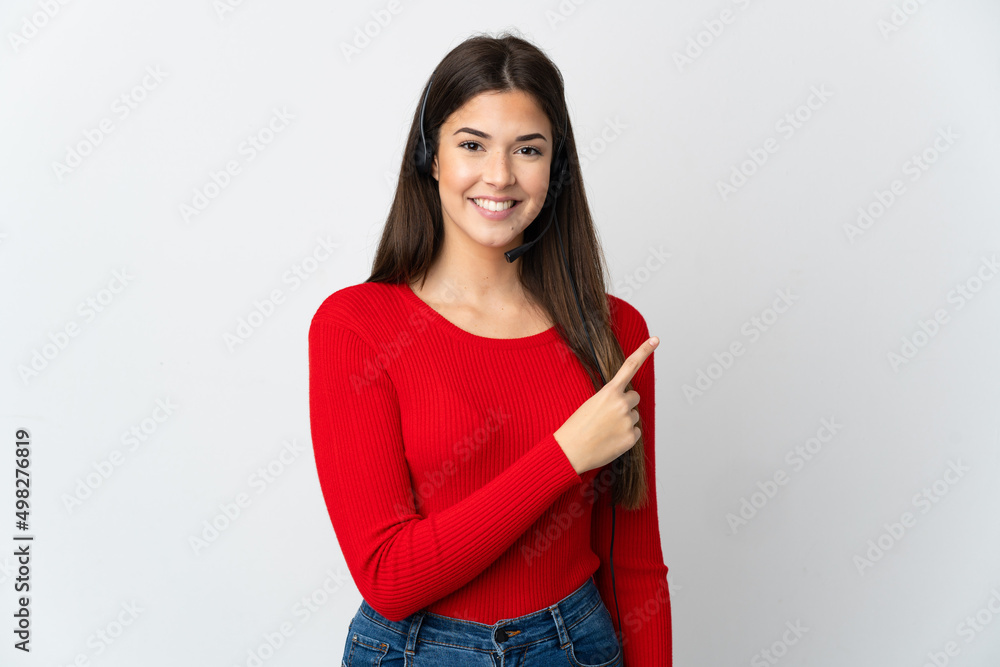 Young Brazilian telemarketer girl over isolated background pointing to the side to present a product Young Brazilian telemarketer girl over isolated background pointing to the side to present a product