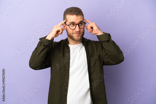 Young handsome caucasian man isolated on purple background having doubts and thinking