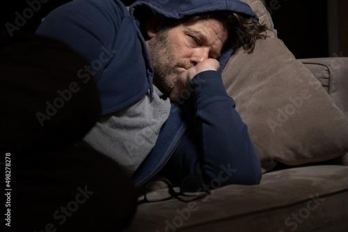 Leinwand Poster Senior Mann mit Migräne oder Depressionen hat sich einsam im dunkeln auf seine Couch zurück gezogen