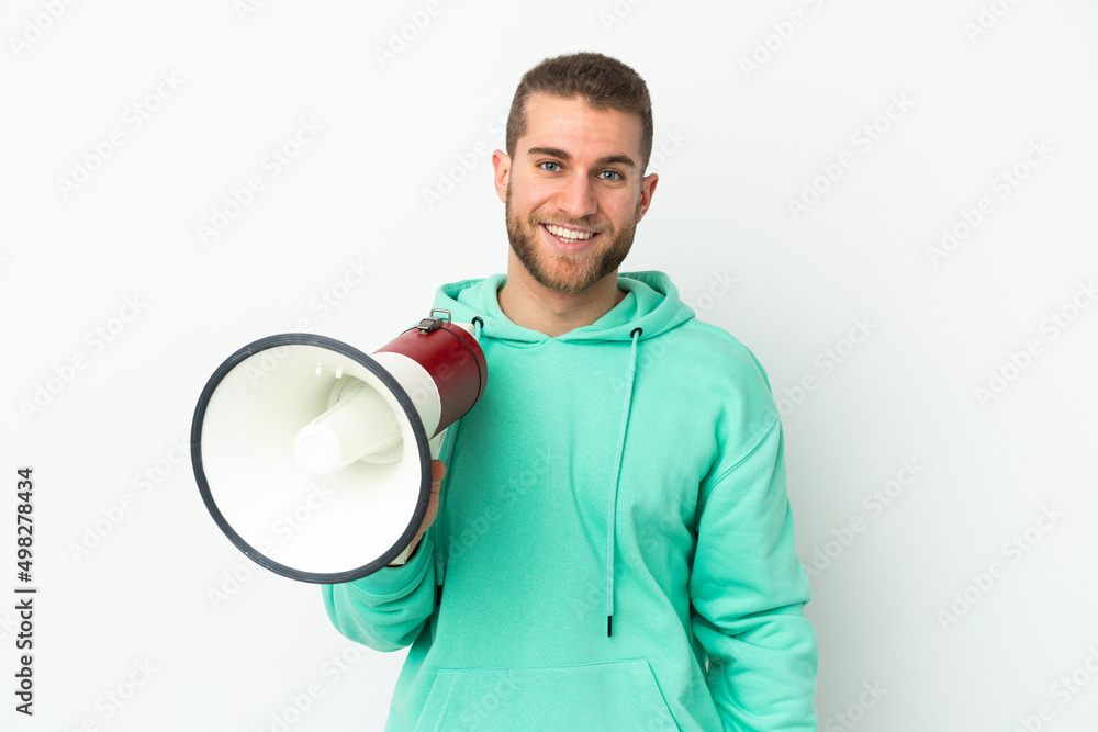 Young handsome caucasian man isolated on white background holding a megaphone and smiling a lot Young handsome caucasian man isolated on white background holding a megaphone and smiling a lot