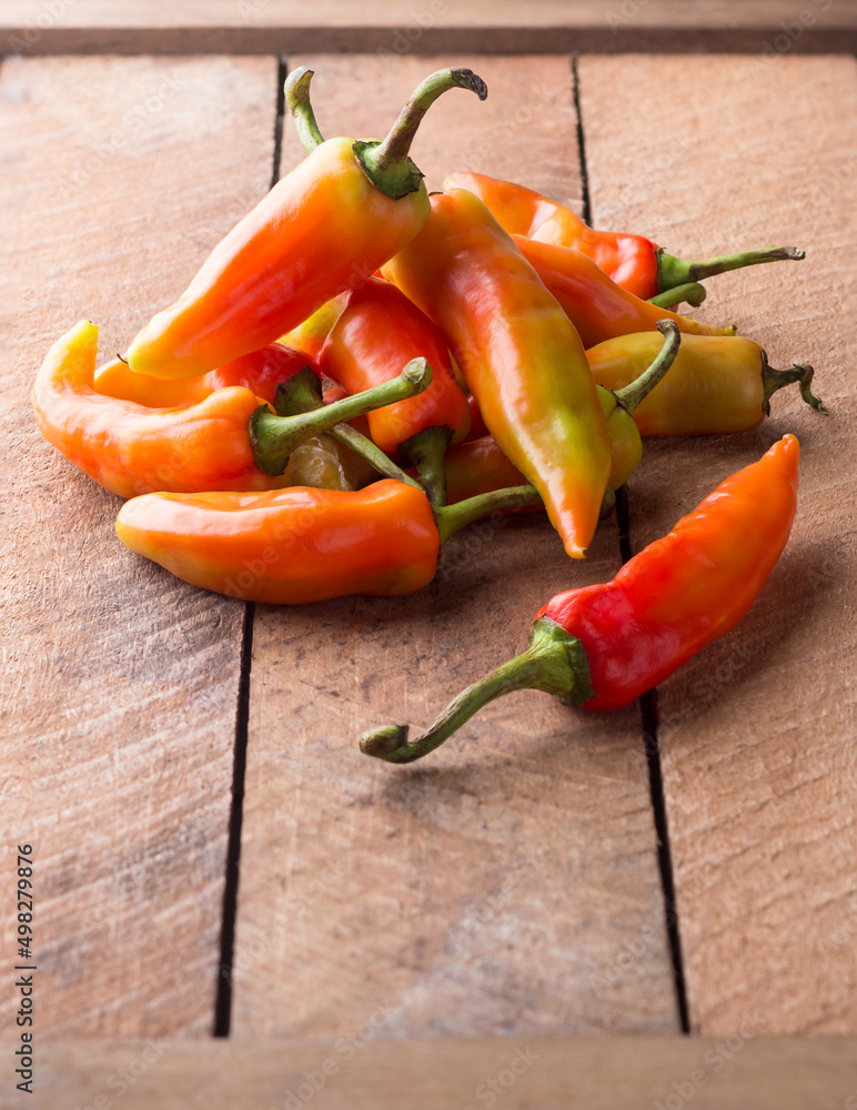 Φωτογραφία vibrant orange and yellow skin chili peppers, fruity flavored, medium in heat bi
