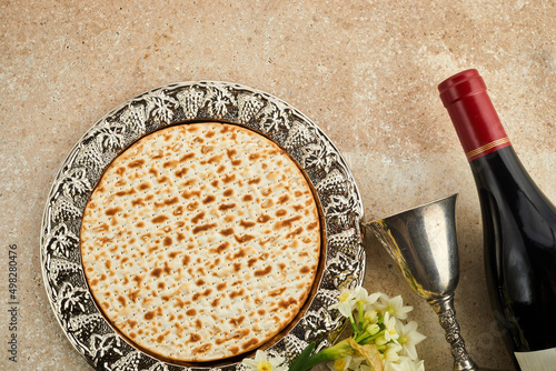 Pesah celebration concept, jewish Passover holiday. Matzah and red kosher. Traditional ritual Jewish bread on travertine stone background