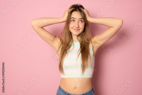 Photo portrait female student touching head both hands crazy amazed staring isolated over pink background