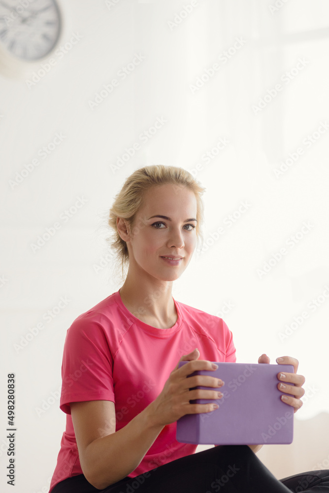 Beautiful blonde woman in sportswear using foam block for fitness training at home Beautiful blonde woman in sportswear using foam block for fitness training at home