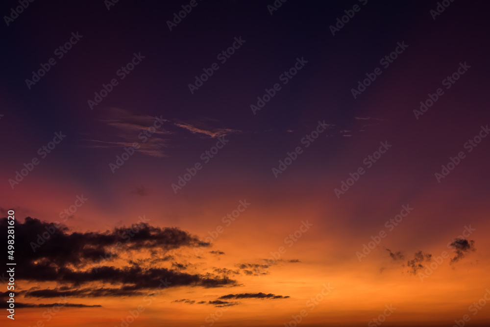 Sunset sky and dark clouds in the evening on twilight with orange sunlight and dark blue background in summer season, Dusk sky 