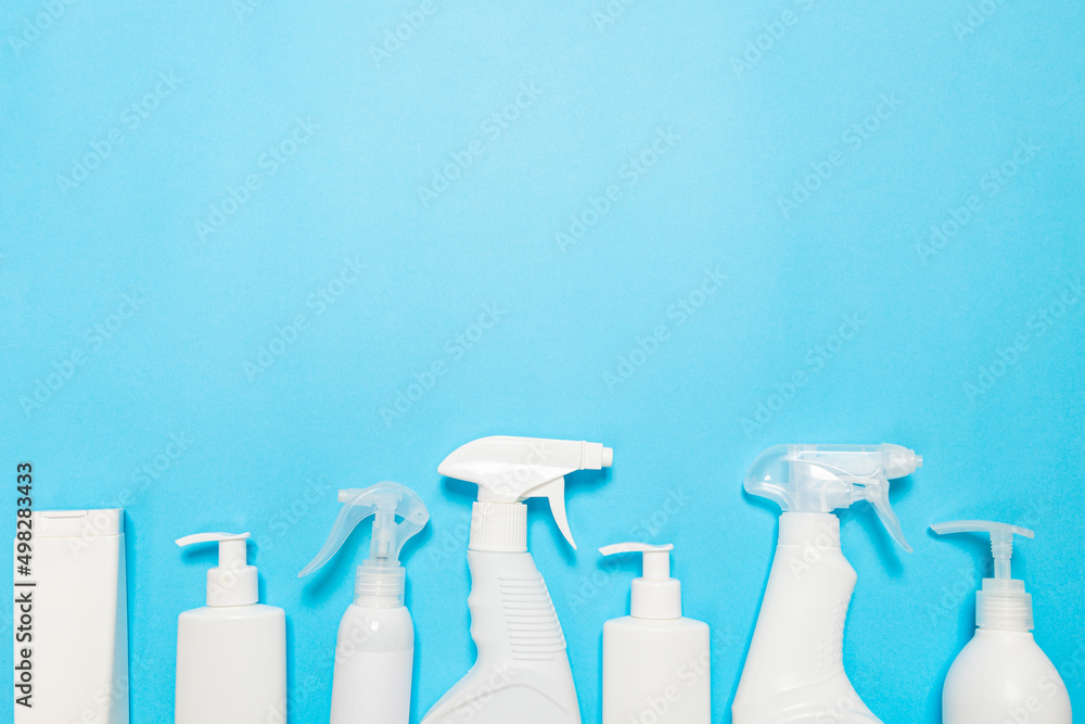 bottles of household chemicals spray and sponges for cleaning and washing on a blue isolated background. Cleaning concept. Banner. bottles of household chemicals spray and sponges for cleaning and washing on a blue isolated background. Cleaning concept. Banner.