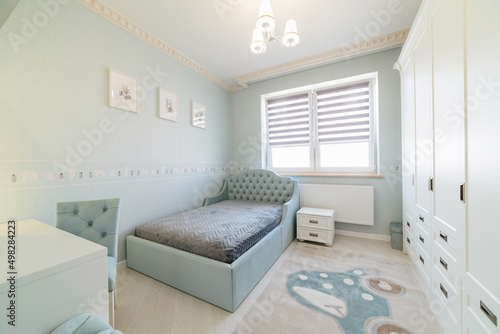 modern interior of a children s room with a large bed  wardrobe and window