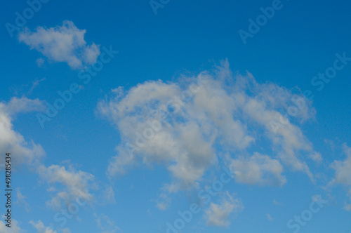 A blue sky with soft white clouds