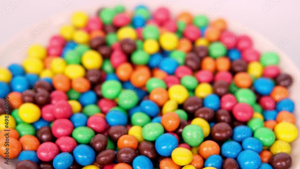 Frankfurt, Germany, October 2021: close-up of multi-colored button-shaped chocolates, each of which has letter Frankfurt, Germany, October 2021: close-up of multi-colored button-shaped chocolates, each of which has letter