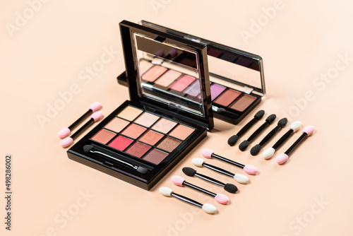 Shadow pallet with appliquators for female eye makeup on an orange background. Female makeup and beauty eye.