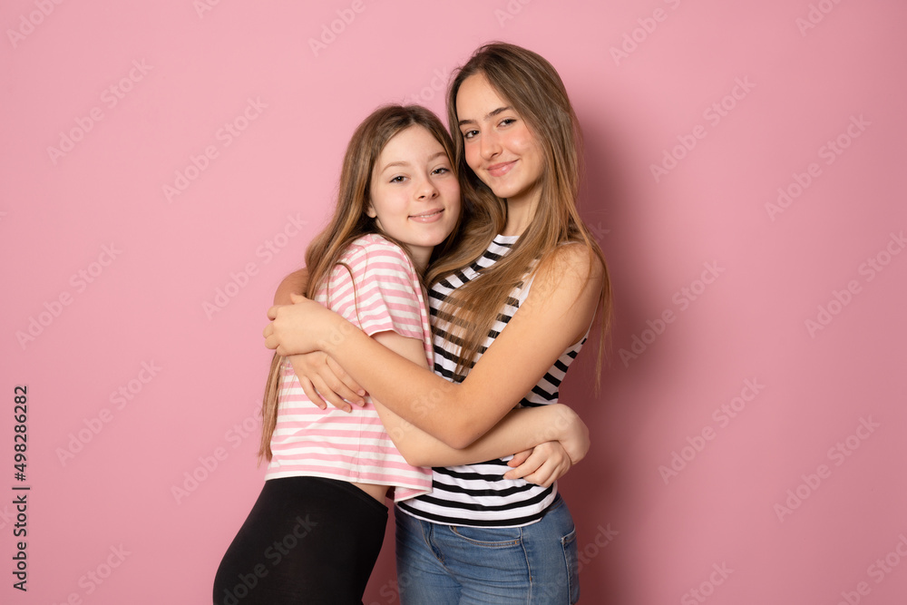 Happy bright positive moments of two stylish girls hugging each other and smiling. Closeup portrait funny joyful attractive young women having fun, lovely moments, best friends. Happy bright positive moments of two stylish girls hugging each other and smiling. Closeup portrait funny joyful attractive young women having fun, lovely moments, best friends.
