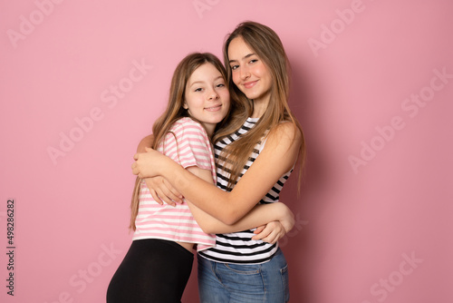 Happy bright positive moments of two stylish girls hugging each other and smiling. Closeup portrait funny joyful attractive young women having fun, lovely moments, best friends.
