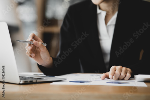 Business woman checking financial documents, she owns a startup company, she sits checking the company's financial summary prepared by the finance department. Management concept of startup company.