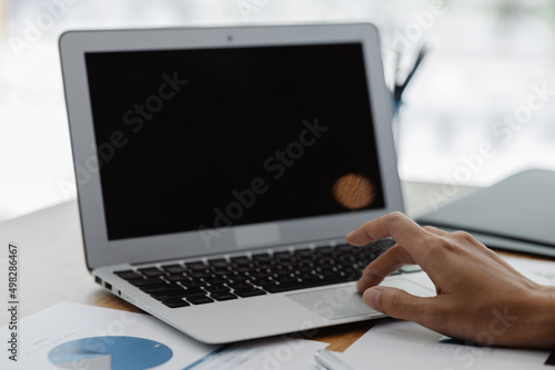 Fototapeta Naklejka Na Ścianę i Meble -  Close-up of hands resting on keyboard to view financial data, business growth in the world of cryptocurrencies and the current global economy with war and volatility. Finance and investment concepts.