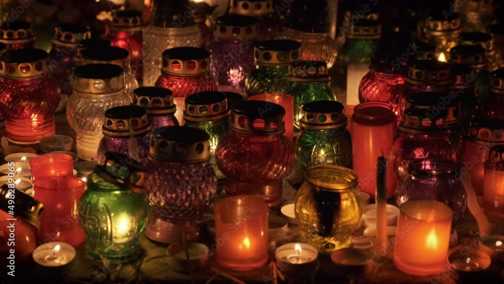 Halloween night. Candles glowing in cemetery at night at all saints day. 4k. 50fps Halloween night. Candles glowing in cemetery at night at all saints day. 4k. 50fps