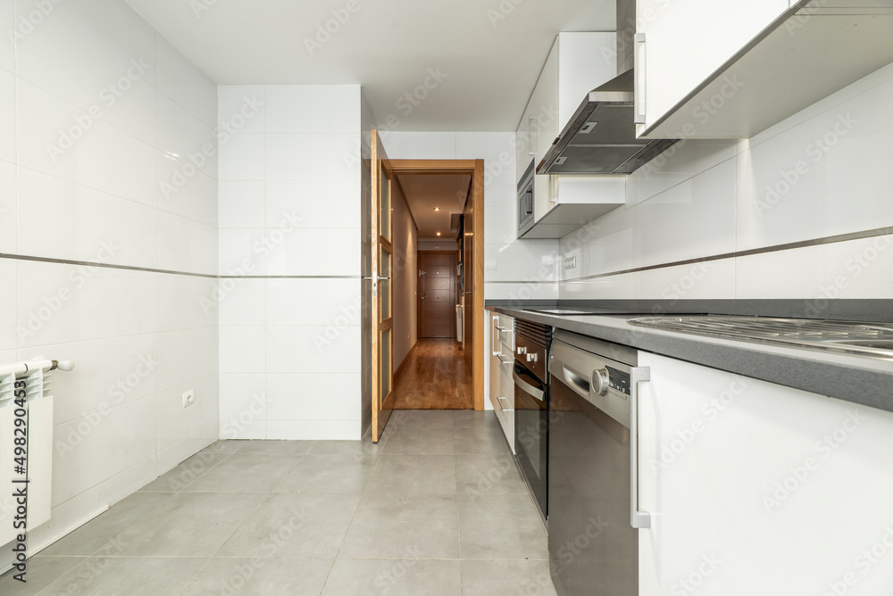Kitchen with white wood cabinets with gray countertops, stainless steel appliances, and tile floors. Kitchen with white wood cabinets with gray countertops, stainless steel appliances, and tile floors.