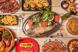 Set of Spanish food dishes with grilled prawns tapa, Galician octopus, baked monkfish, mini beef burgers, grilled chop, padron peppers and french fries