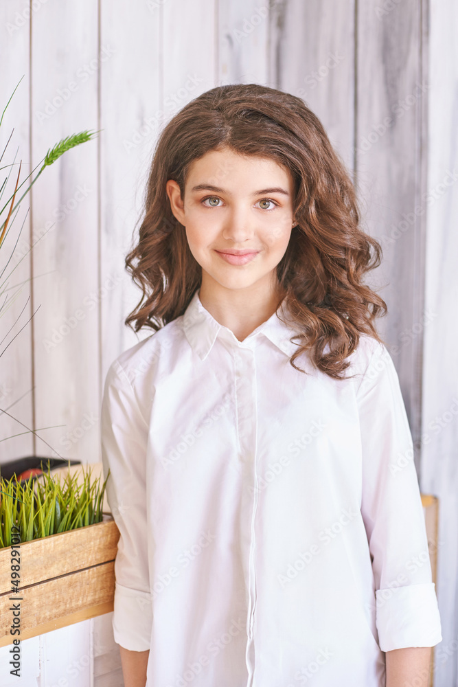 Young girl studio portrait. Curly pretty child. Student looking at camera. Attractive brunette. Children emotion Young girl studio portrait. Curly pretty child. Student looking at camera. Attractive brunette. Children emotion