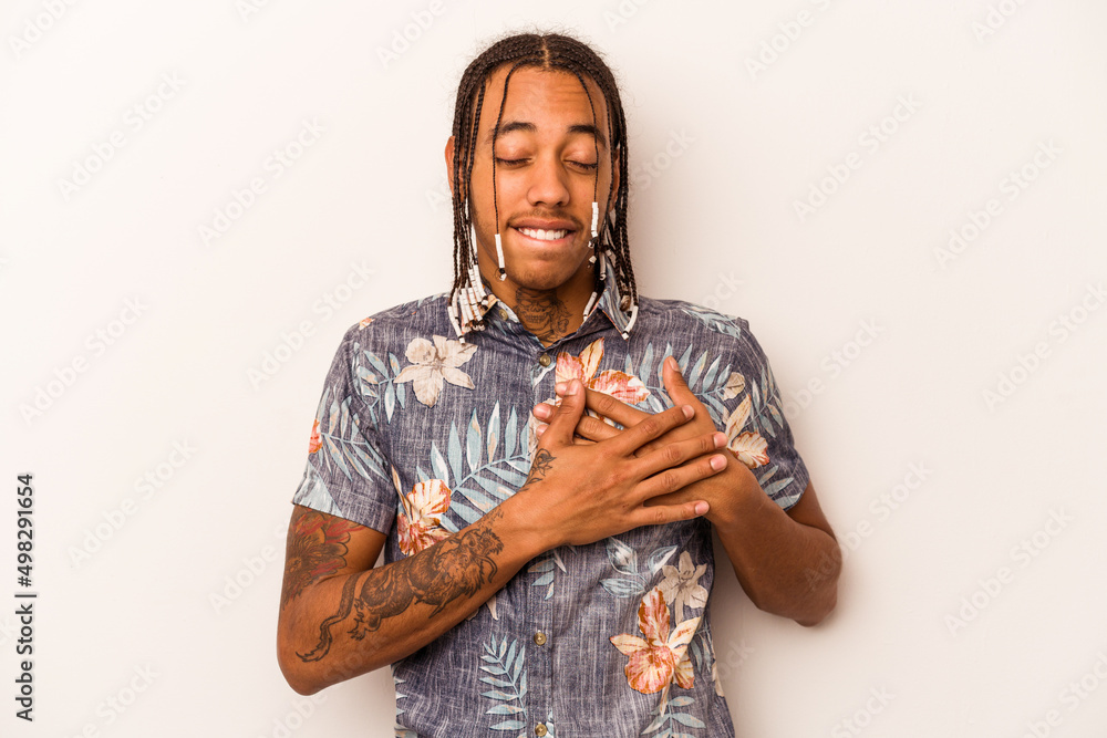 Obraz premium Young African American man isolated on white background has friendly expression, pressing palm to chest. Love concept.