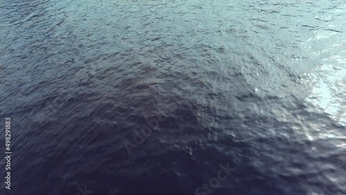 clear blue water shimmers in the sun glare on the water a deep river flows. High quality 4k footage