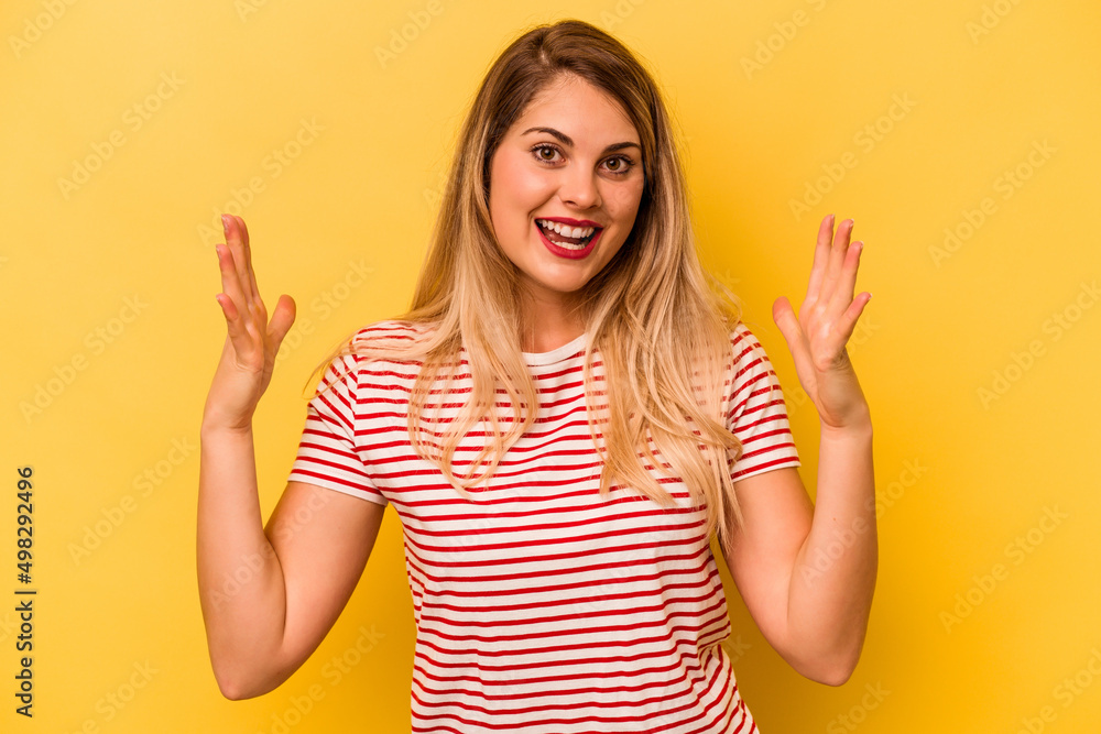 Young caucasian woman isolated on yellow background celebrating a victory or success, he is surprised and shocked. Young caucasian woman isolated on yellow background celebrating a victory or success, he is surprised and shocked.