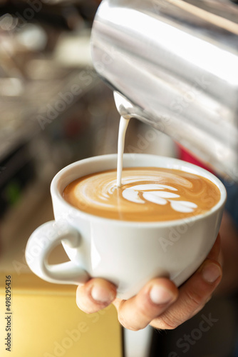 barista pouring cup of coffee