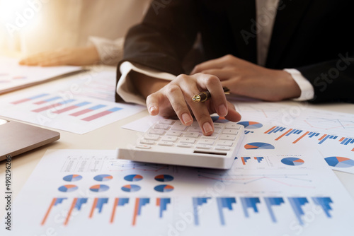 Businesswoman or accoutant calculates financials with graph report on the table on the cost of office Fototapet