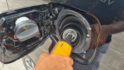a driver fills a diesel additive into a car's diesel fuel tank to increase the cetane number and lower the sulfur content of biodiesel photo