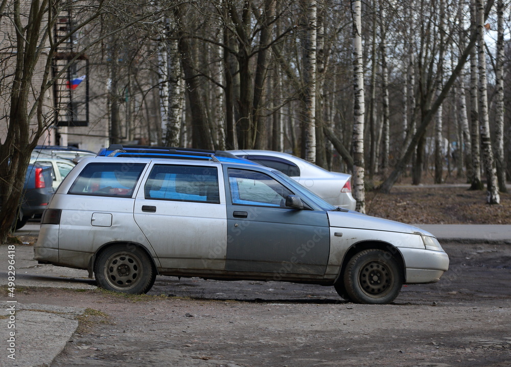 Old light silver car with dark door, Iskrovsky Prospekt, St. Petersburg, Russia, April 2022