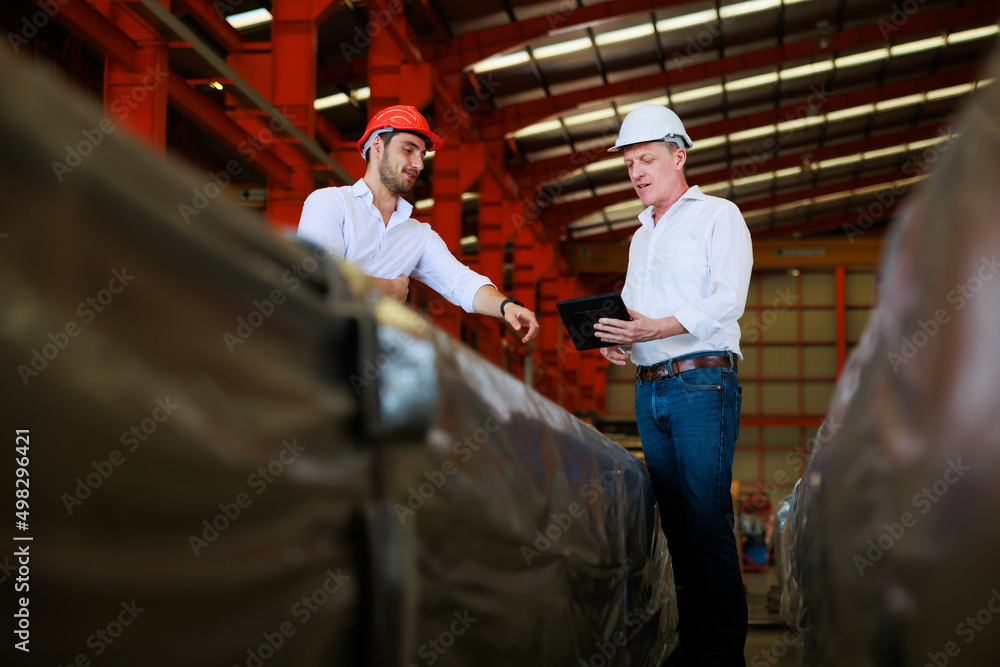 Caucasian business man and Factory engineer talking and discussion at Heavy Industry Manufacturing Factory. worker in safety hardhat at factory industrial facilities Caucasian business man and Factory engineer talking and discussion at Heavy Industry Manufacturing Factory. worker in safety hardhat at factory industrial facilities