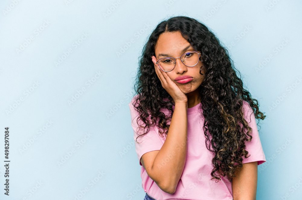 Young hispanic woman isolated on blue background who feels sad and pensive, looking at copy space. Young hispanic woman isolated on blue background who feels sad and pensive, looking at copy space.
