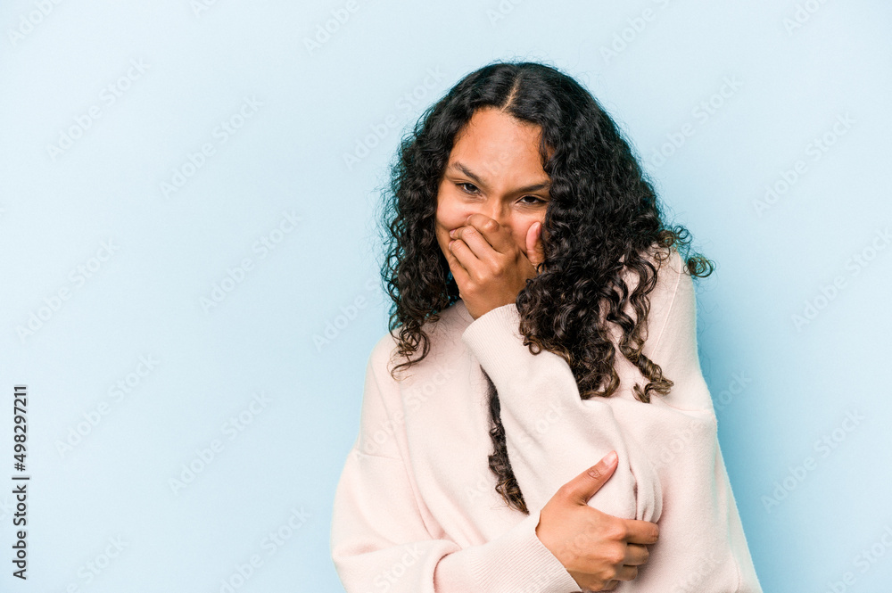 Young hispanic woman isolated on blue background laughing happy, carefree, natural emotion.