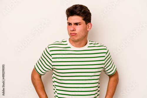 Young caucasian man isolated on white background confused, feels doubtful and unsure.