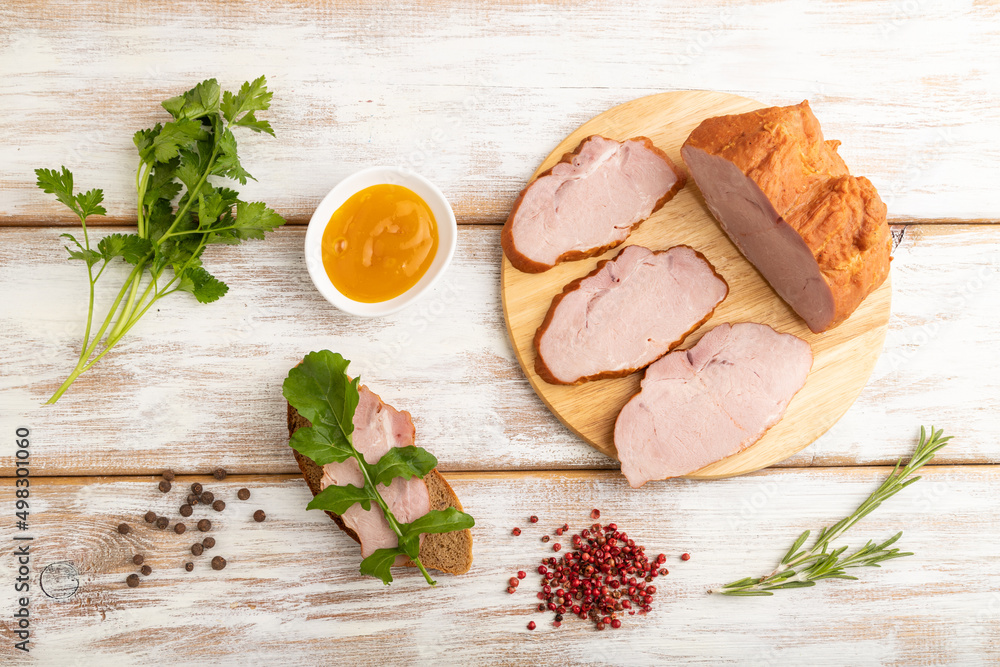 Smoked pork ham on cutting board on white wooden background. Top view, close up. Smoked pork ham on cutting board on white wooden background. Top view, close up.