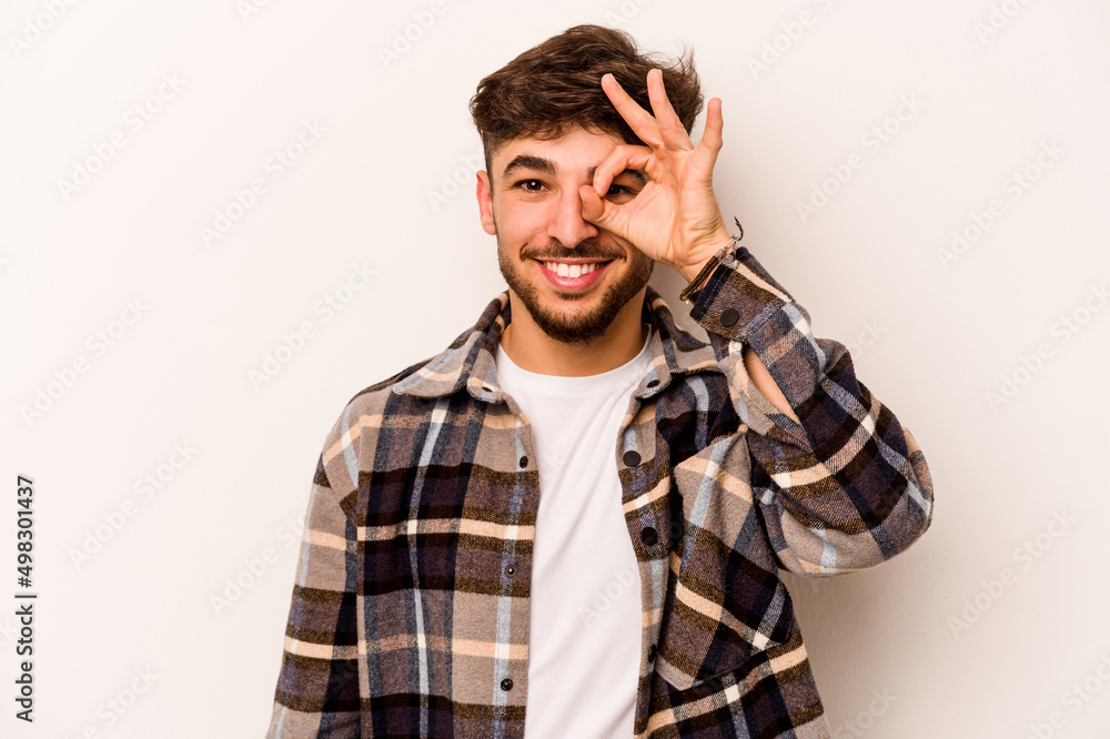 Young hispanic man isolated on white background excited keeping ok gesture on eye. Young hispanic man isolated on white background excited keeping ok gesture on eye.