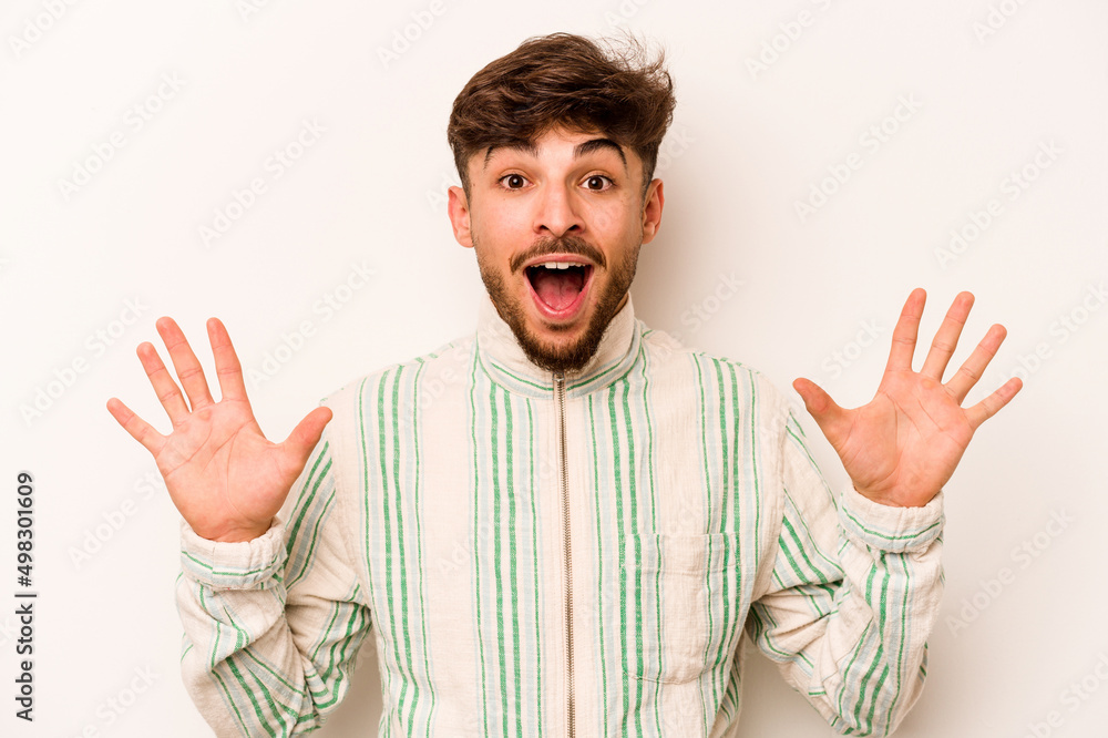 Young hispanic man isolated on white background receiving a pleasant surprise, excited and raising hands. Young hispanic man isolated on white background receiving a pleasant surprise, excited and raising hands.