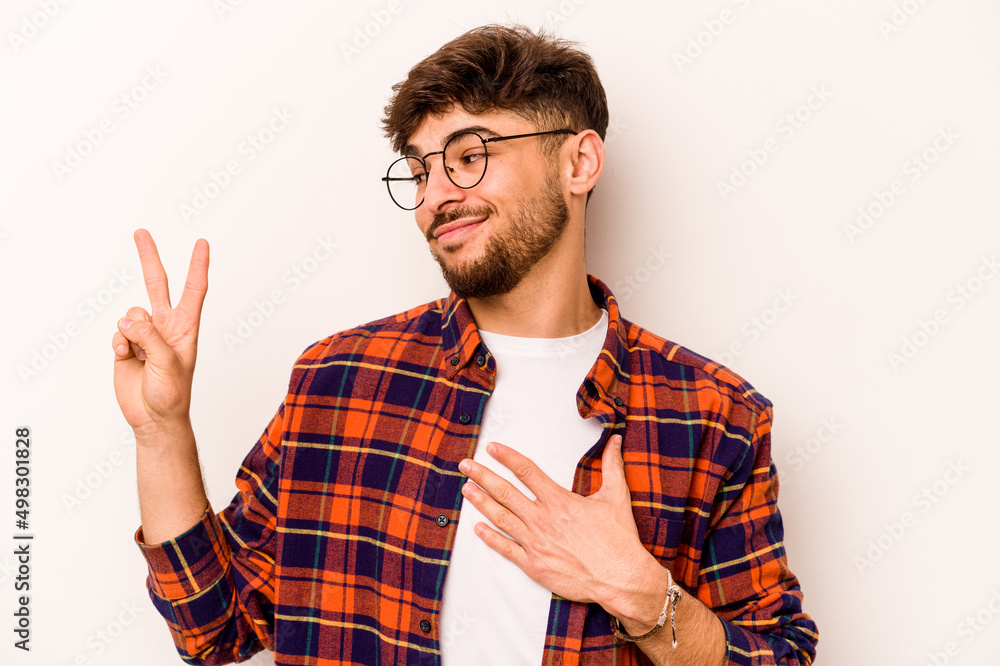 Young hispanic man isolated on white background taking an oath, putting hand on chest. Young hispanic man isolated on white background taking an oath, putting hand on chest.