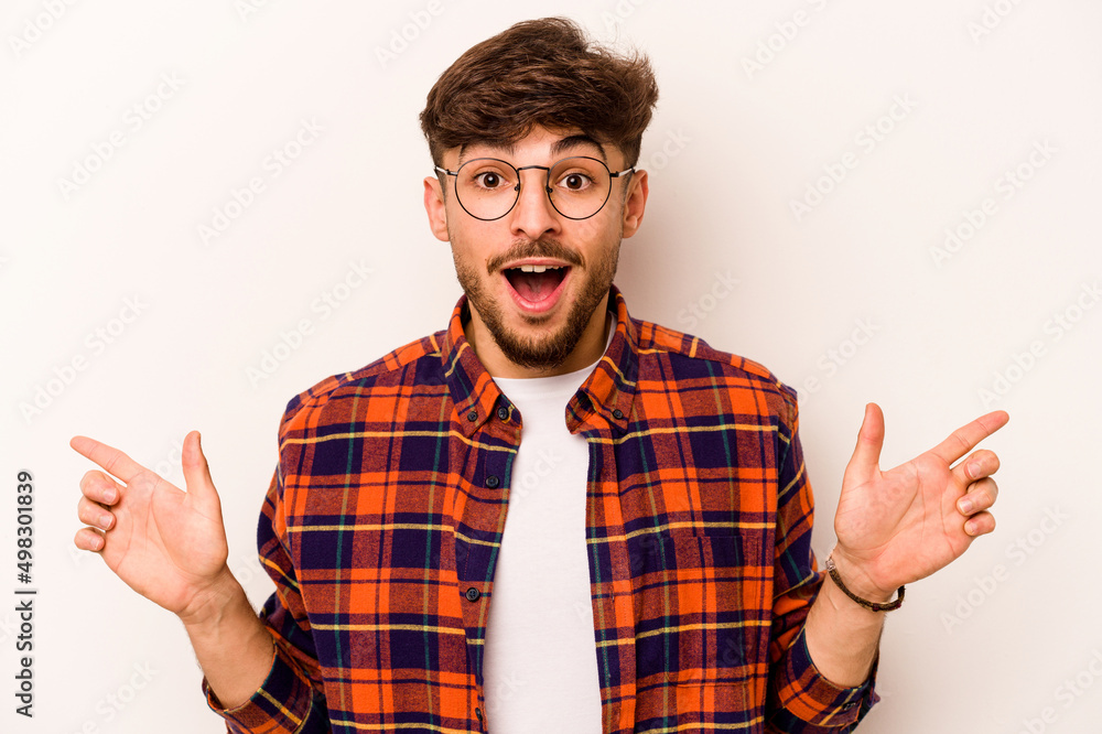 Young hispanic man isolated on white background pointing to different copy spaces, choosing one of them, showing with finger. Young hispanic man isolated on white background pointing to different copy spaces, choosing one of them, showing with finger.