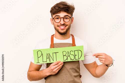 Young gardener man holding plant based placard isolated on white background photo