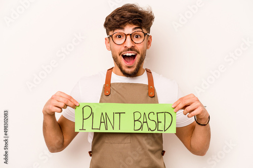 Young gardener man holding plant based placard isolated on white background photo